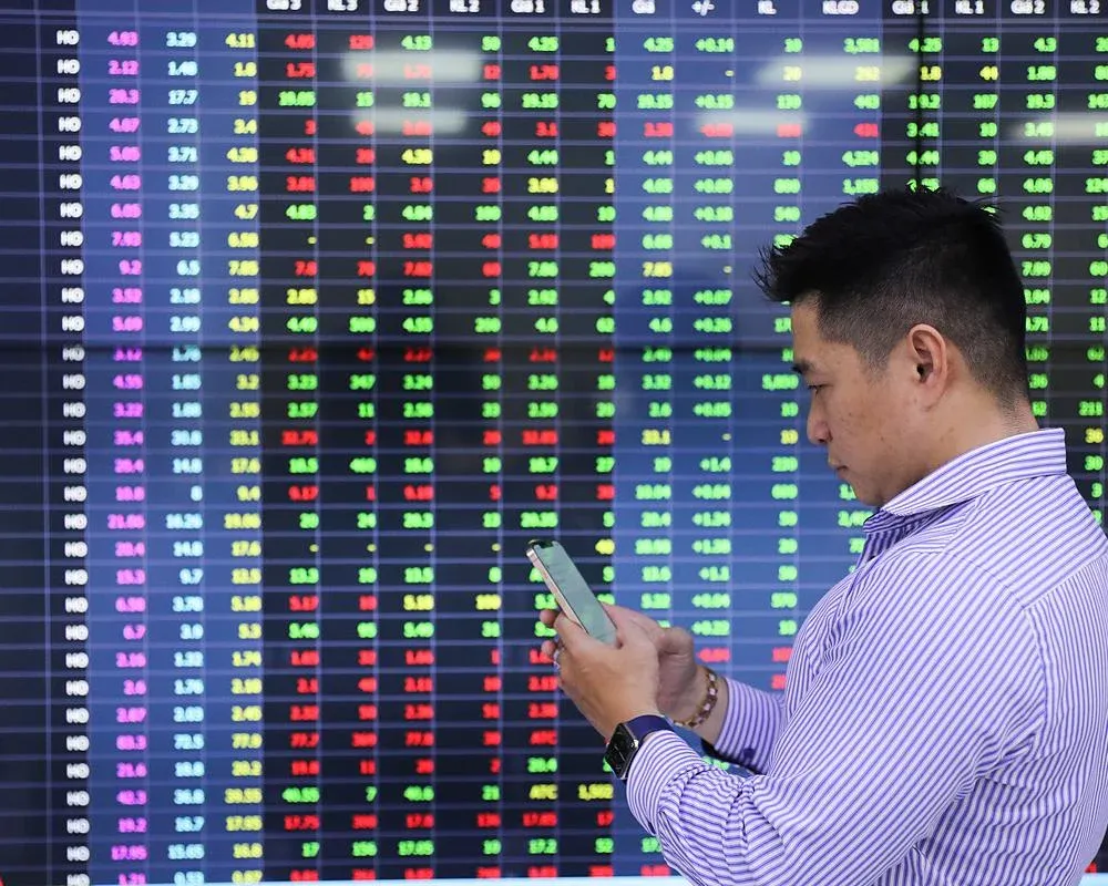 Individual investors watching a stock ticker board