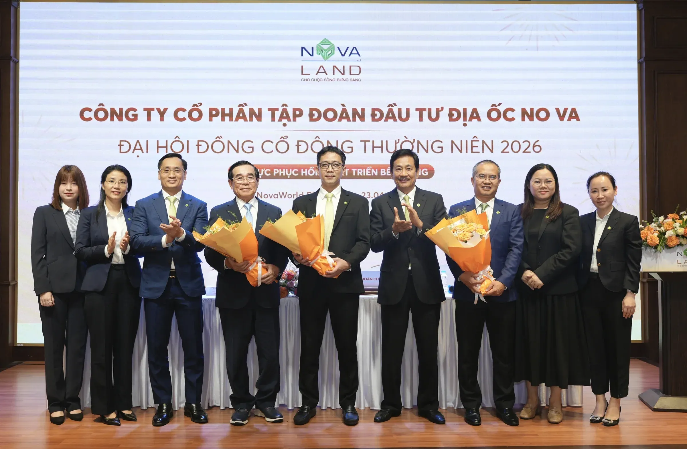 Novaland executives at the 2026 Annual General Meeting, Mr. Bui Cao Nhat Quan (in blue, center) receiving flowers after being elected Chairman